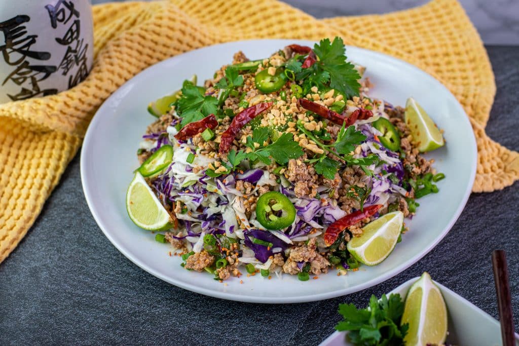 Keto Thai egg roll bowl garnished with chopped peanuts and lime