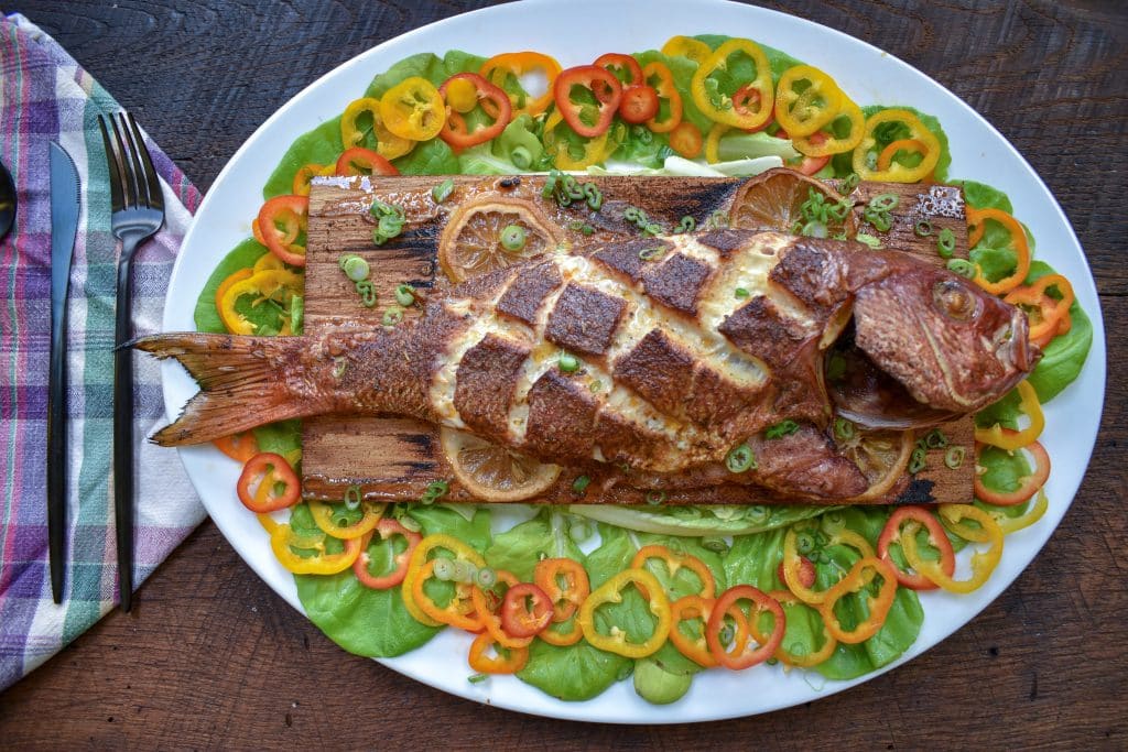 Smoked Whole Red Snapper on oval plate with folded napkin to look like a fish tail