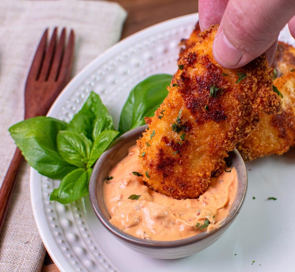 Dipping Low carb Pizza Chicken Tender into calabrian chile aioli