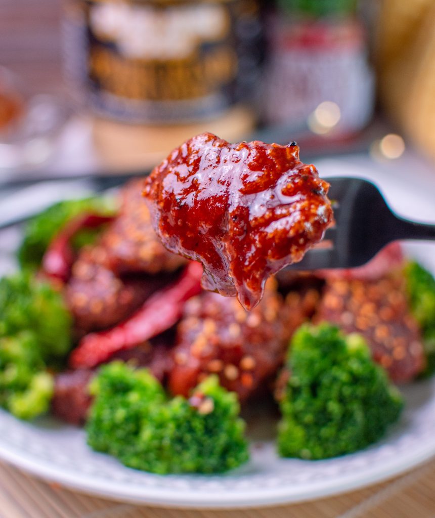 Single piece of low carb general tso chicken on a fork