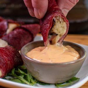 dipping pastrami roll ups into Russian dressing