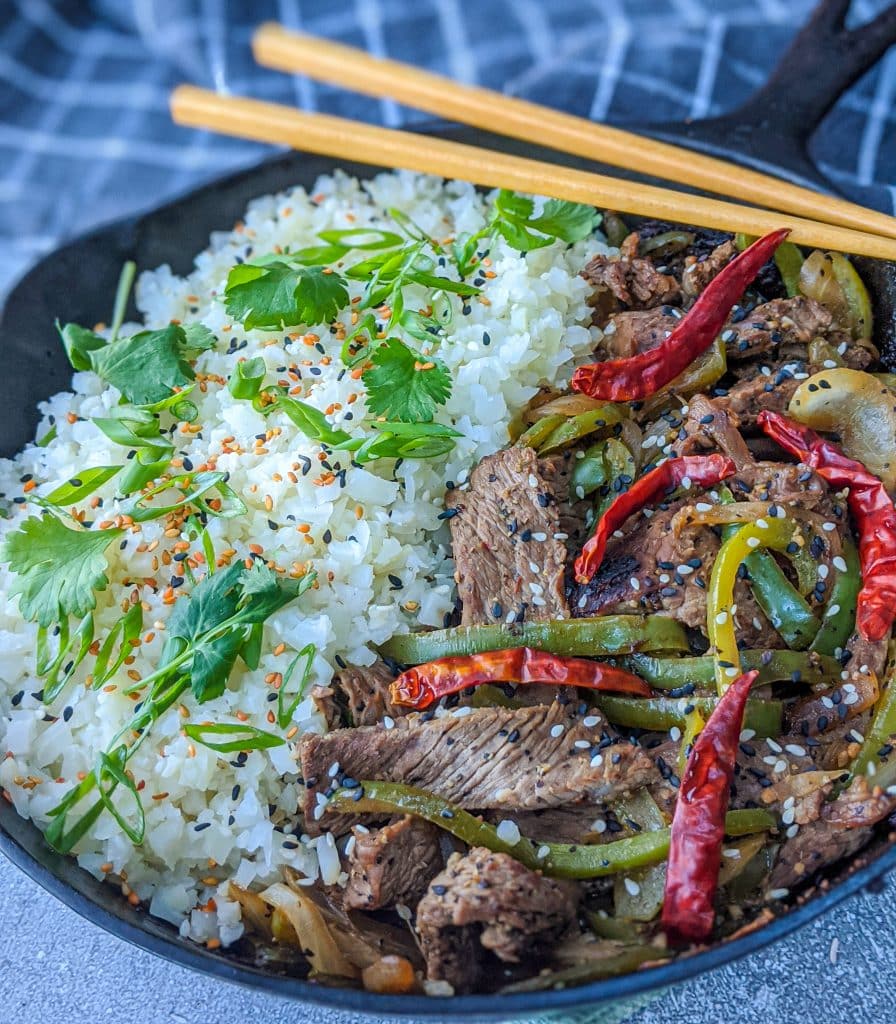 Low carb pepper steak in cast iron skillet with chop sticks