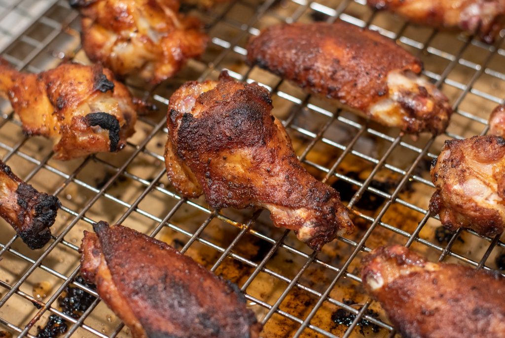 smoked wings reheated on a wire cooling rack on top of a sheet pan
