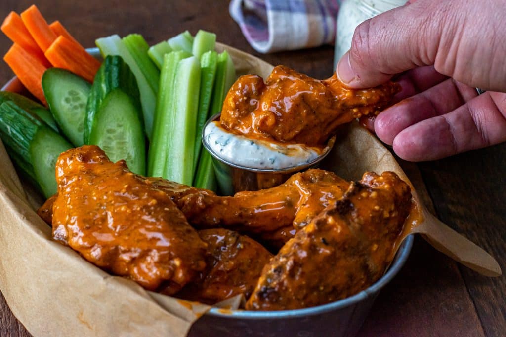 a garlic parmesan wing dipped in ranch dressing