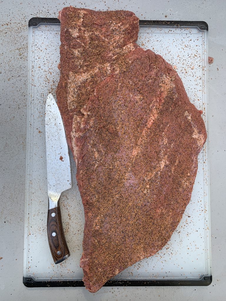 Trimmed raw Texas brisket with salt and pepper rub