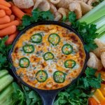 Low carb banging buffalo chicken dip topped with bleu cheese and jalapeños