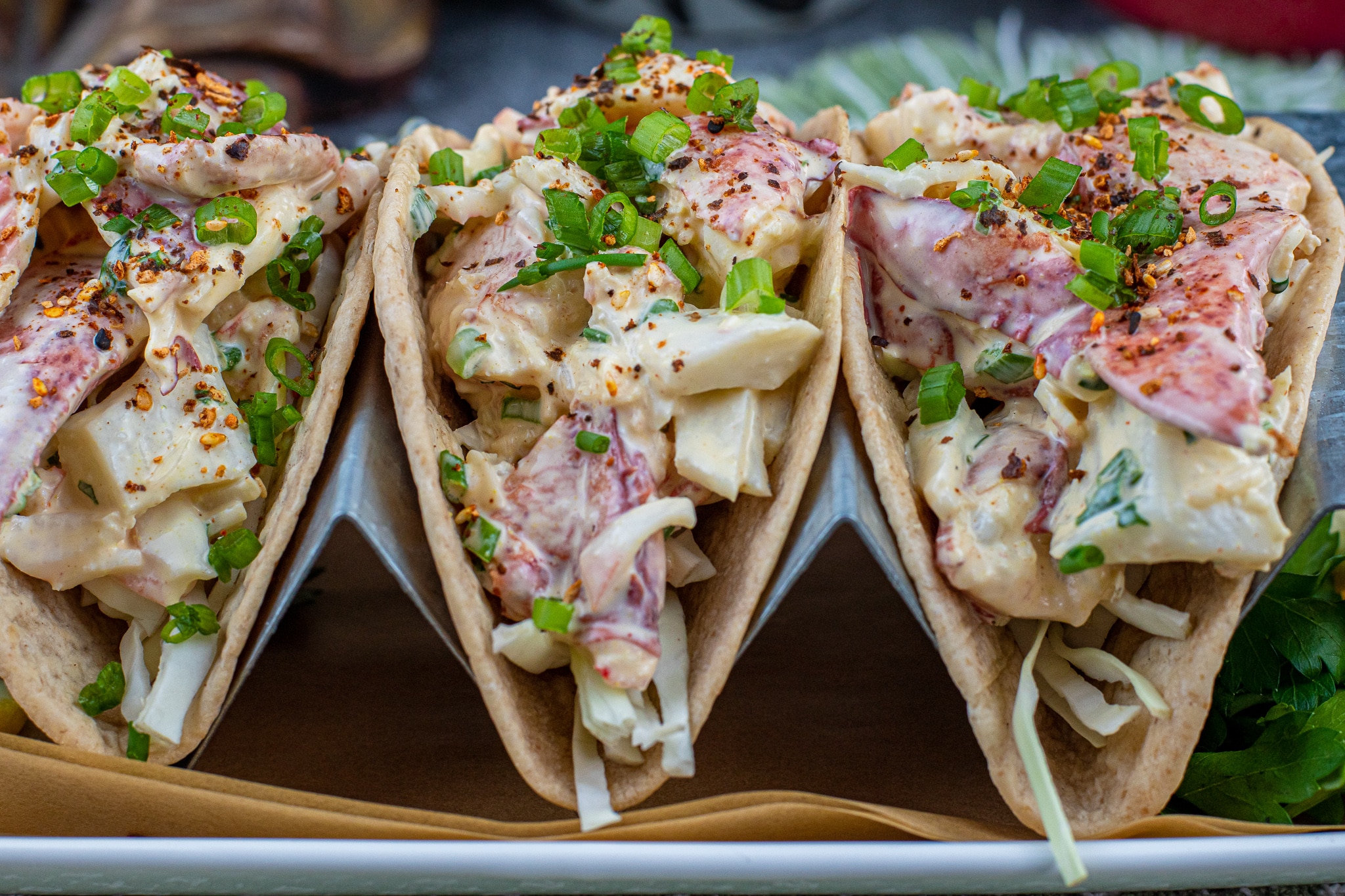 sriracha lobster roll tacos topped with scallions and togarashi
