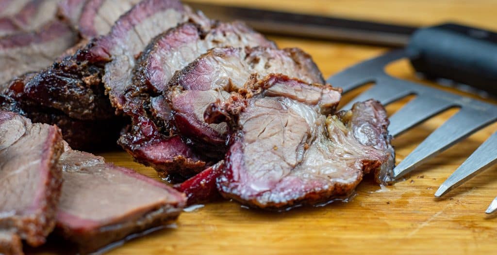 sliced smoked chuck roast on a cutting board