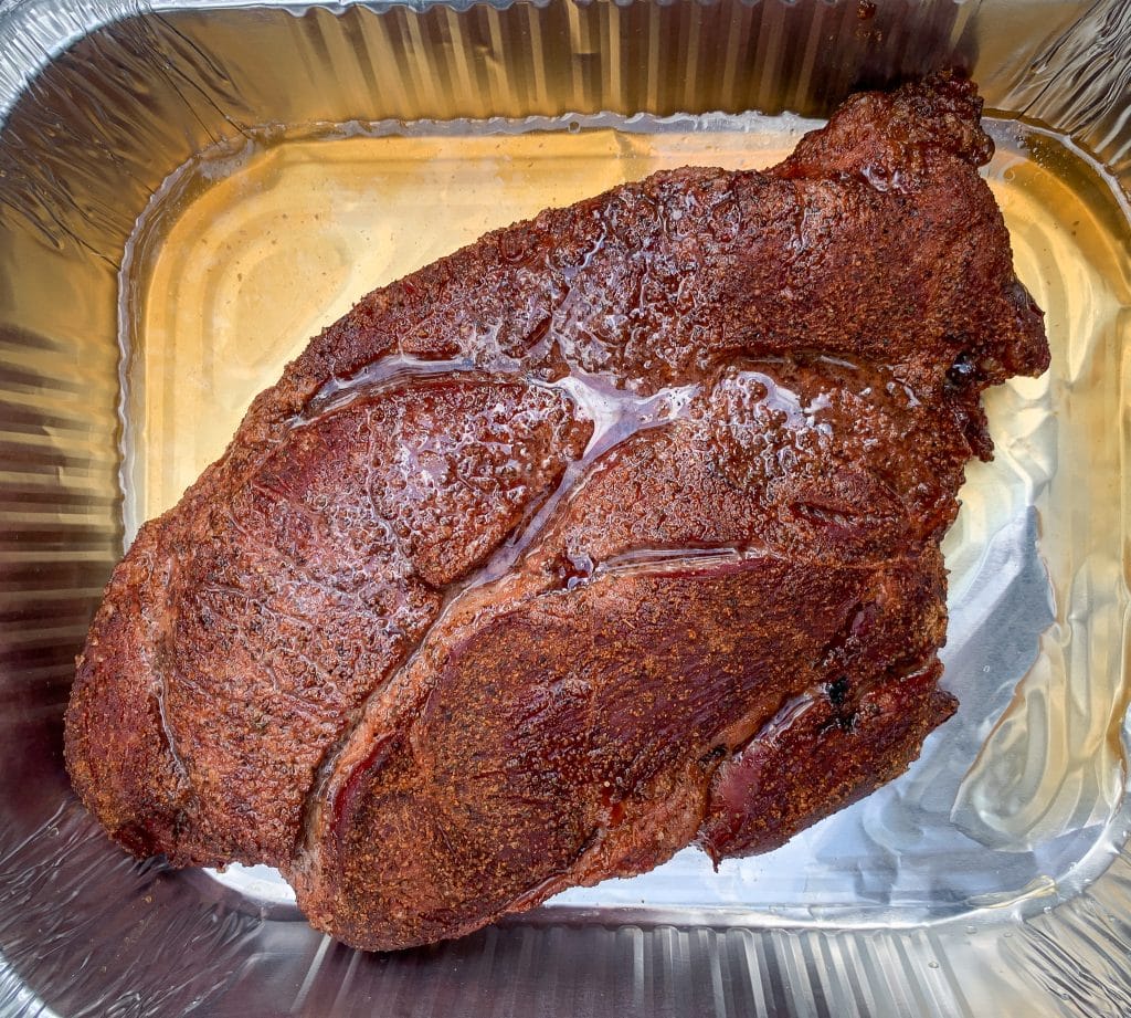 smoked chuck roast braising in a aluminum pan