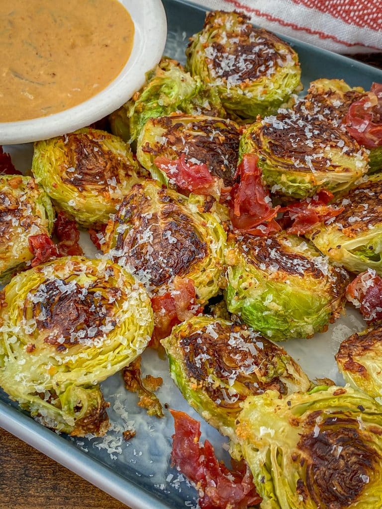 keto roasted brussel sprouts topped with Parmesan Cheese and crispy prosciutto