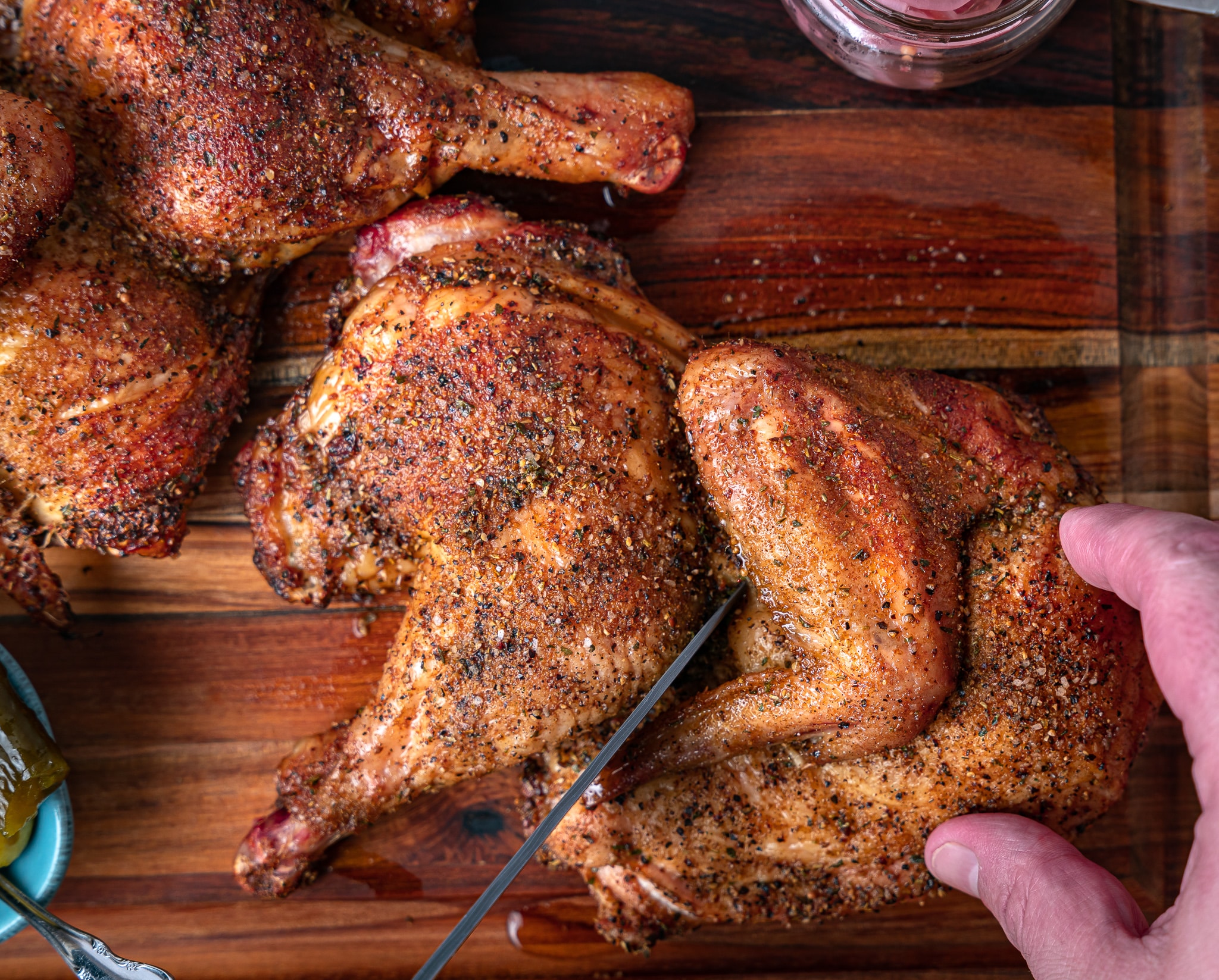 separating cooked chicken into quarters