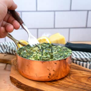 keto creamed spinach in a pan with sliced lemon