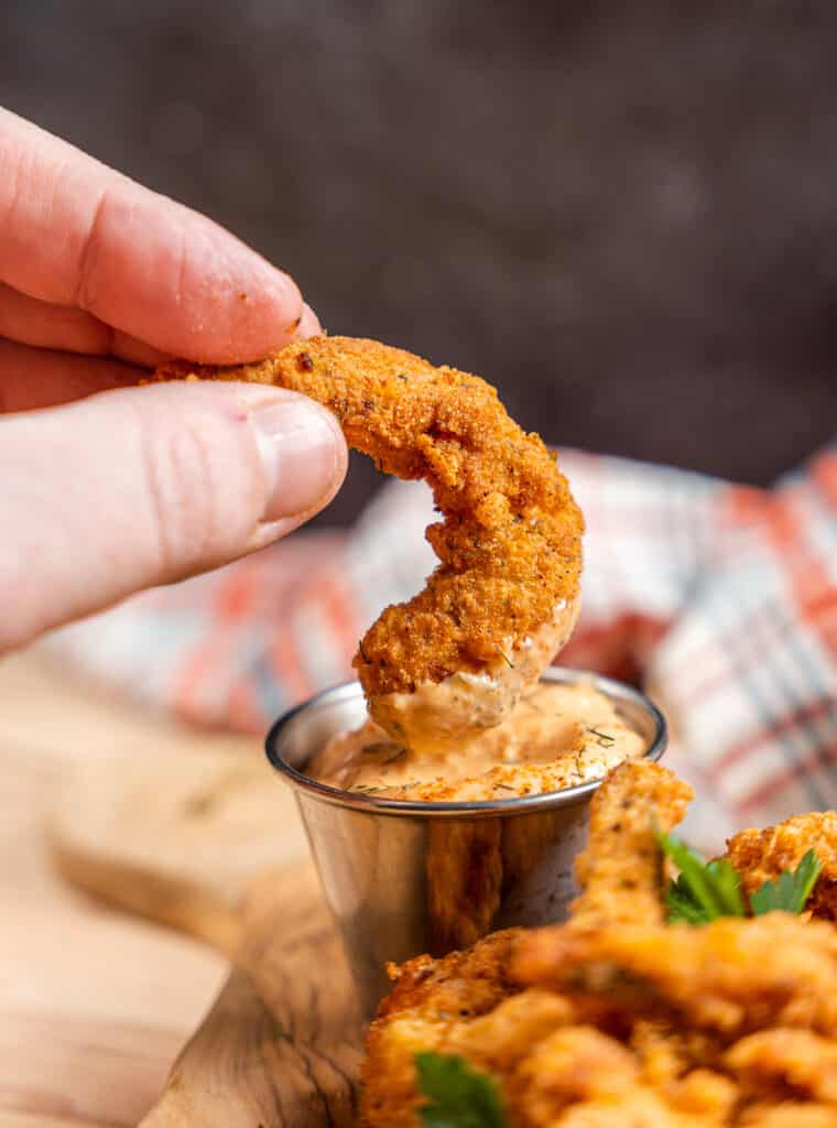 dipping keto fried shrimp in spicy aioli