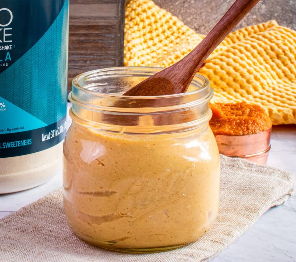 protein cheese cake in a jar with a wooden spoon